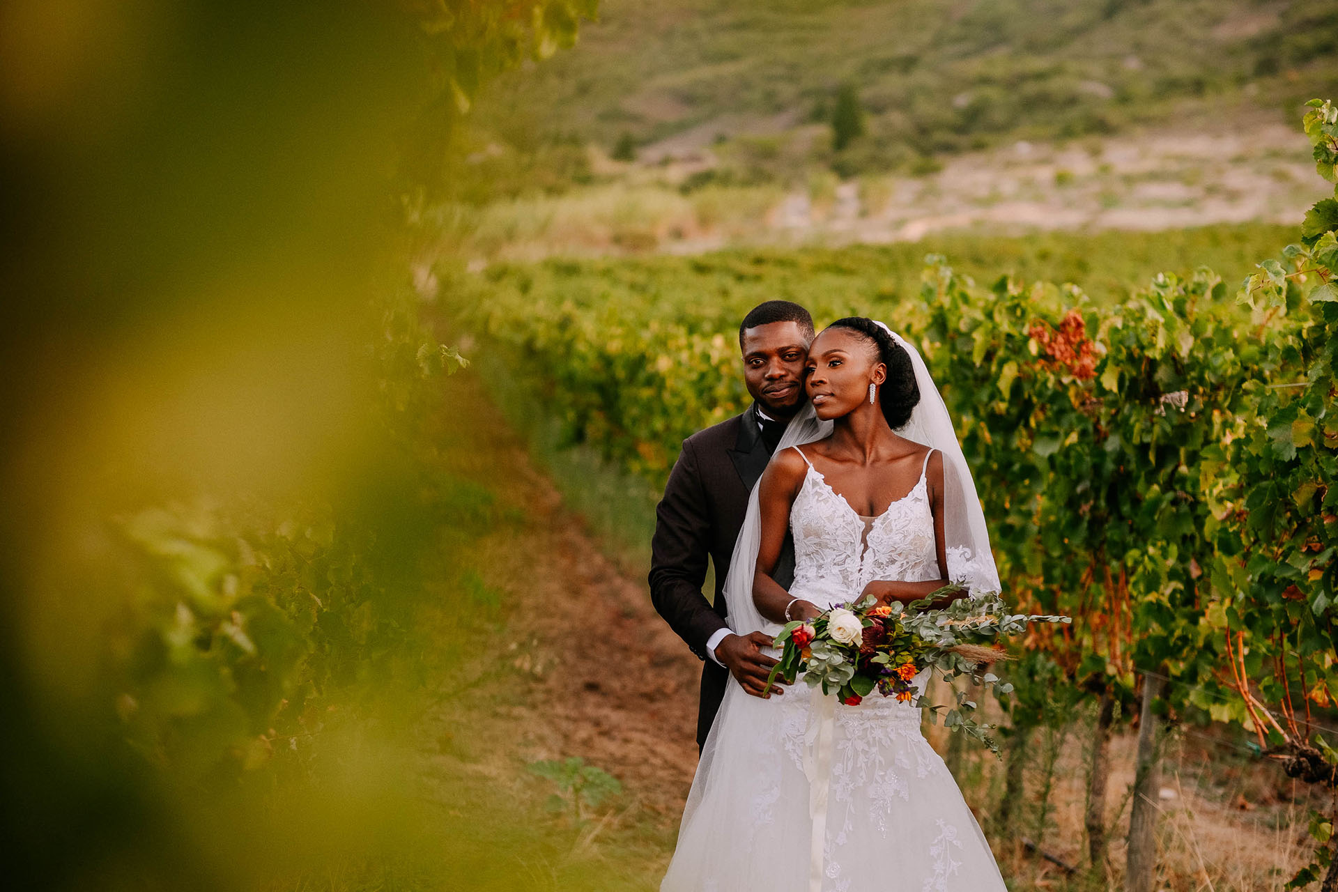 a bride and groom look out between the rhebokskloof vineyards in paarl that offers inspired by nature wedding venues