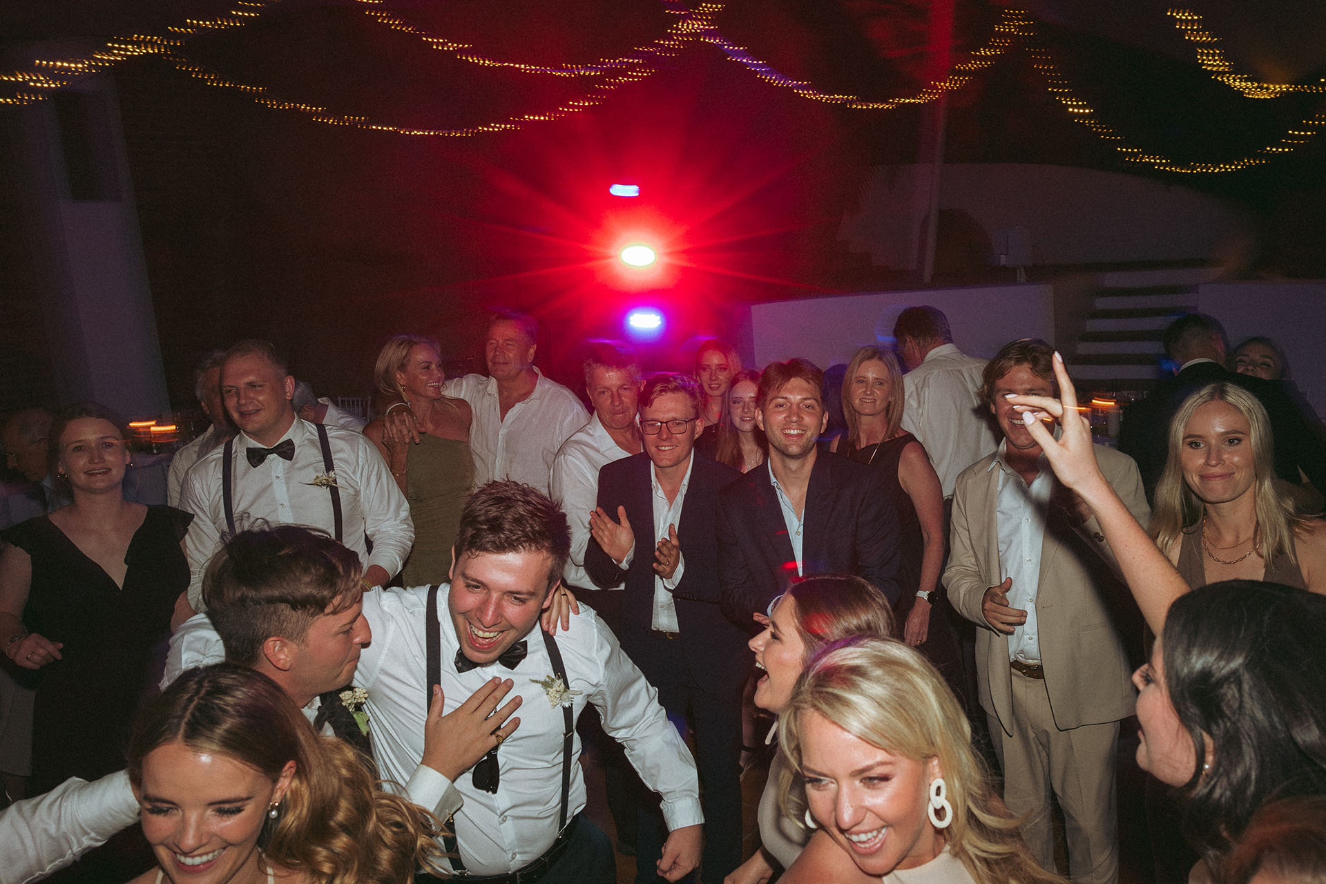 wedding guests dance the night away amongst the light strobes at the tented reception venue at Rhebokskloof that offer an elegant summer wedding venue too.