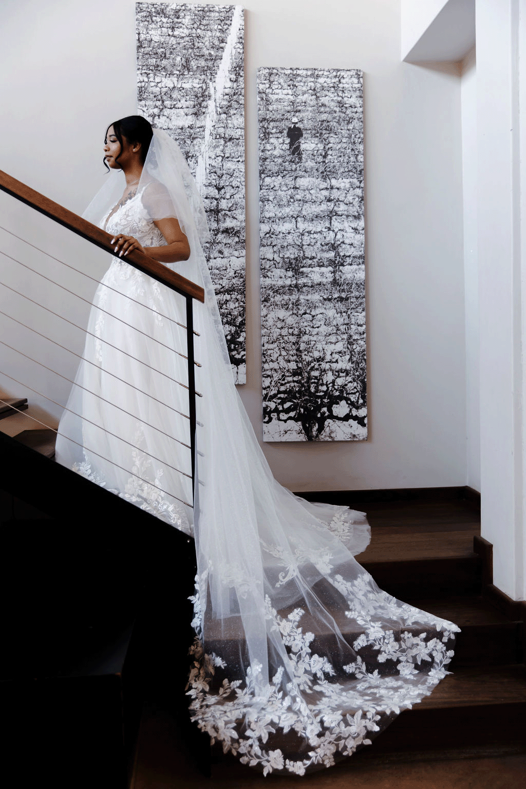 a bride at Rhebokskloof Estate poses on the stairs showing off her long white wedding gown she wore for her winter wedding in Paarl.
