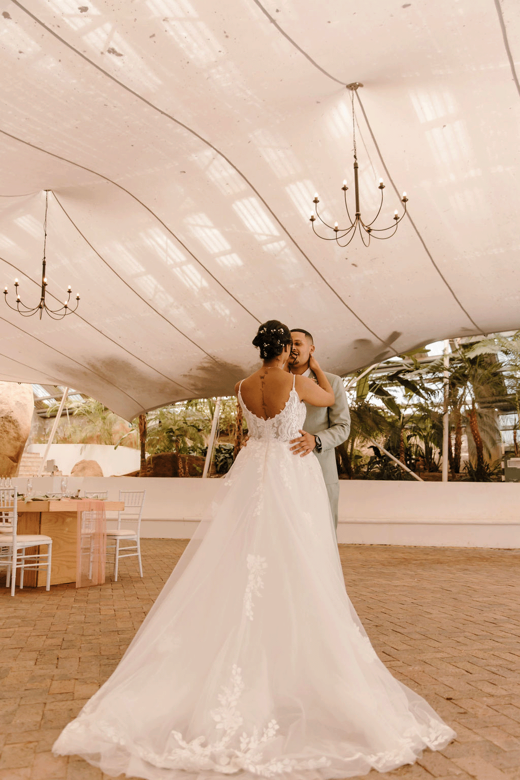 a young bride and groom stand in a beautiful wedding venue in Paarl filled with natural light and foliage.