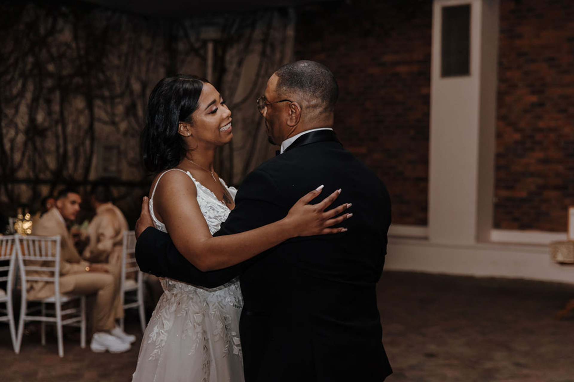 a newlywed bride looks happily at her father as they do the father-daughter dance at Rhebokskloof Estate which served as the perfect winter wedding venue.