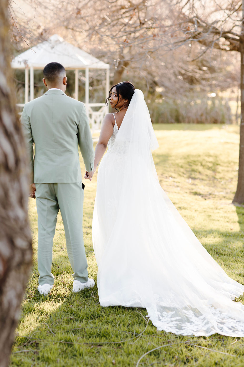 young newlyweds walk amidst the wintery landscape at Rhebokskloof on their wedding day amidst the bare trees.