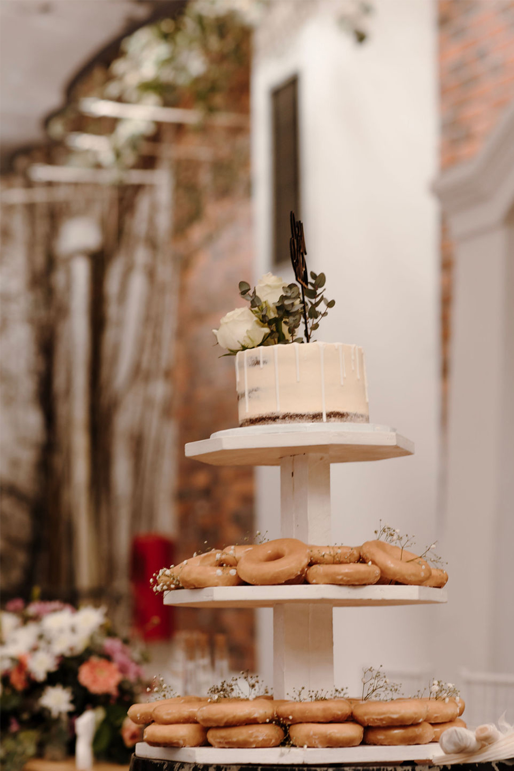 a wedding cake on the top tier with glazed donuts on the lower tears at one of the most beautiful winter wedding venues in the western cape.