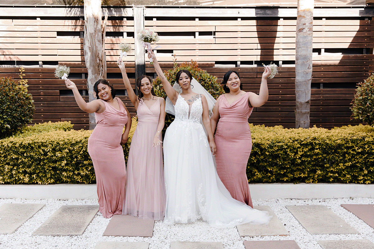 A bride posing with her 3 bridesmaids all dressed in dusty pink and white for her Cape winter wedding theme.